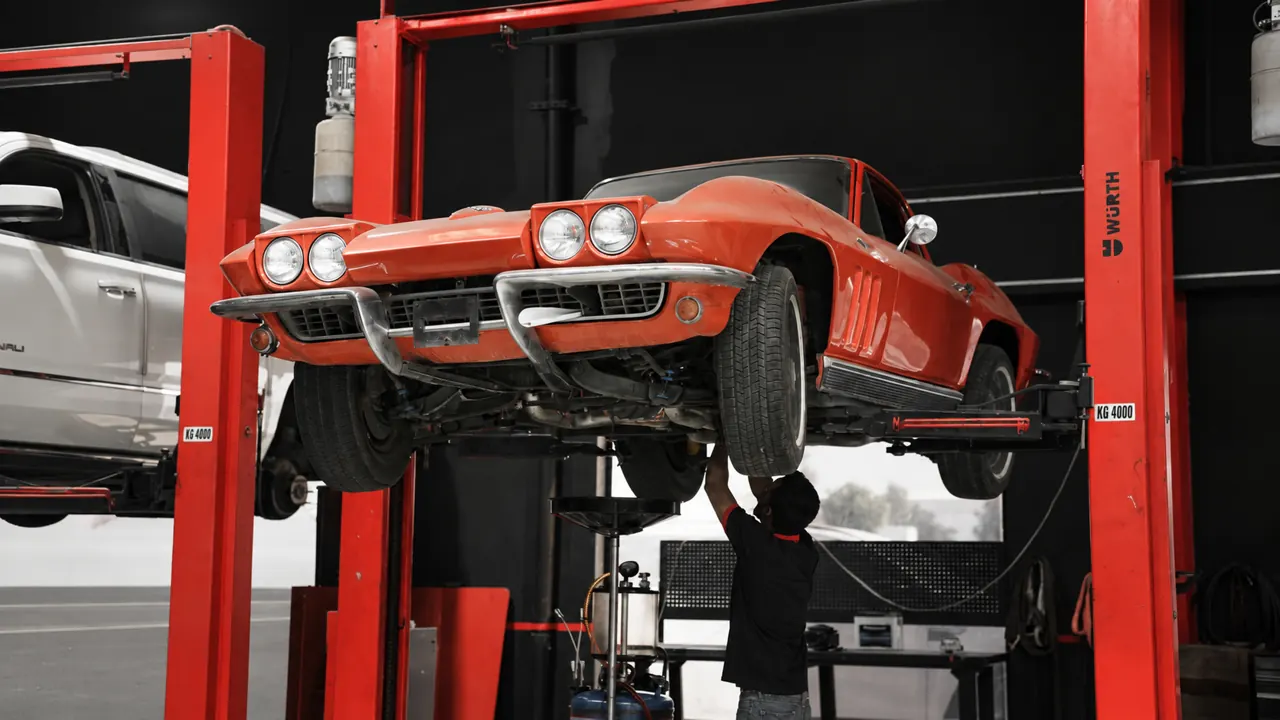 A classic C2 Corvette raised on a lift in the bay at Al Zaabi Autocare, Mussafah