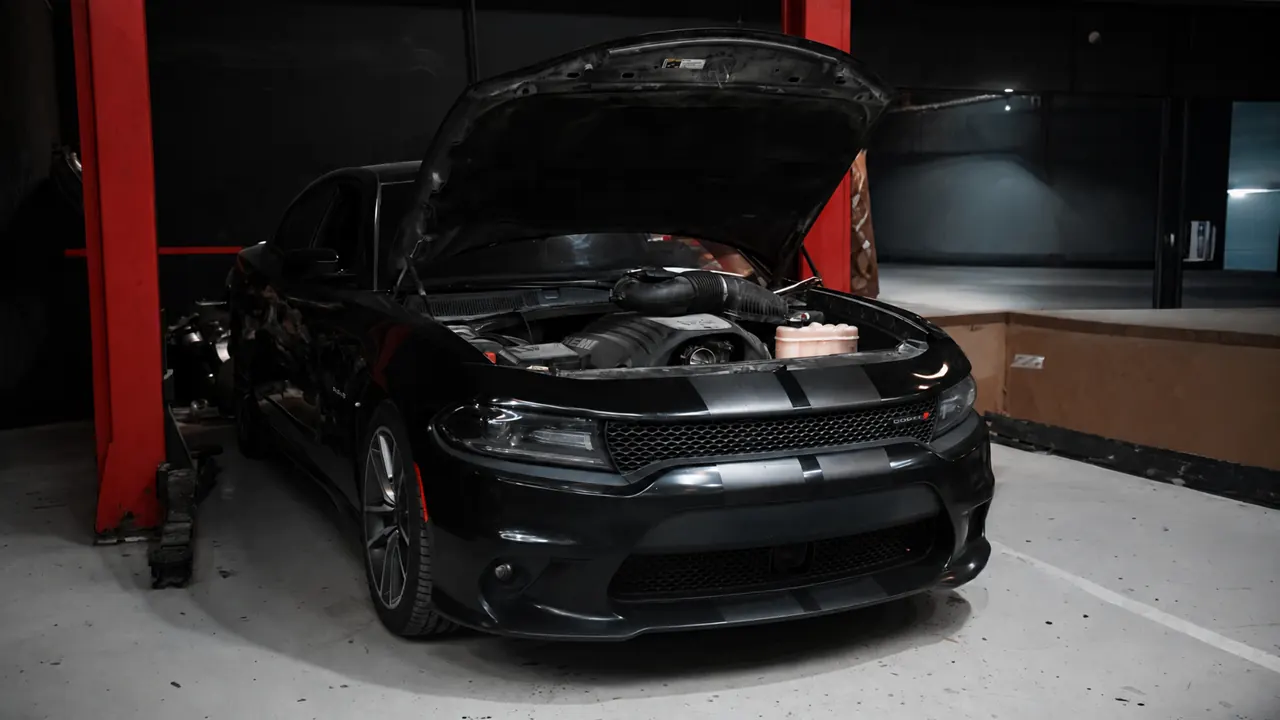A Dodge Charger with the bonnet up in the bay at Al Zaabi Autocare, Mussafah