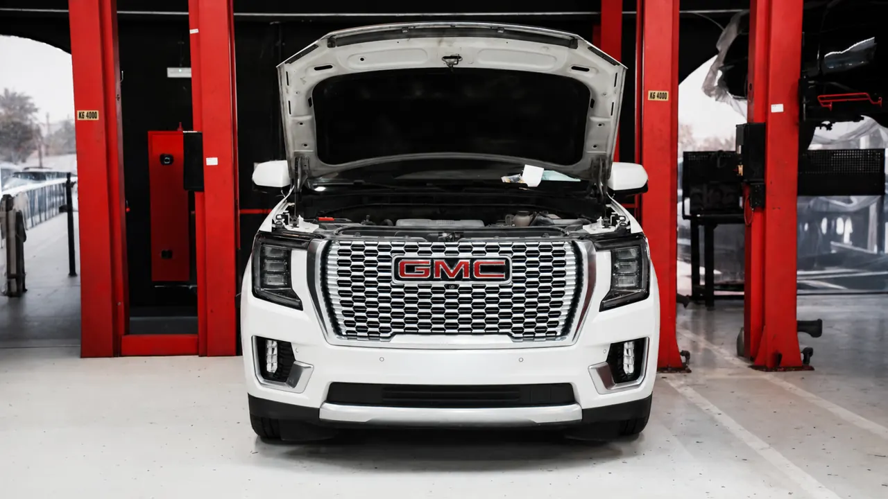 A GMC Yukon Denali with the bonnet up in the bay at Al Zaabi Autocare, Mussafah