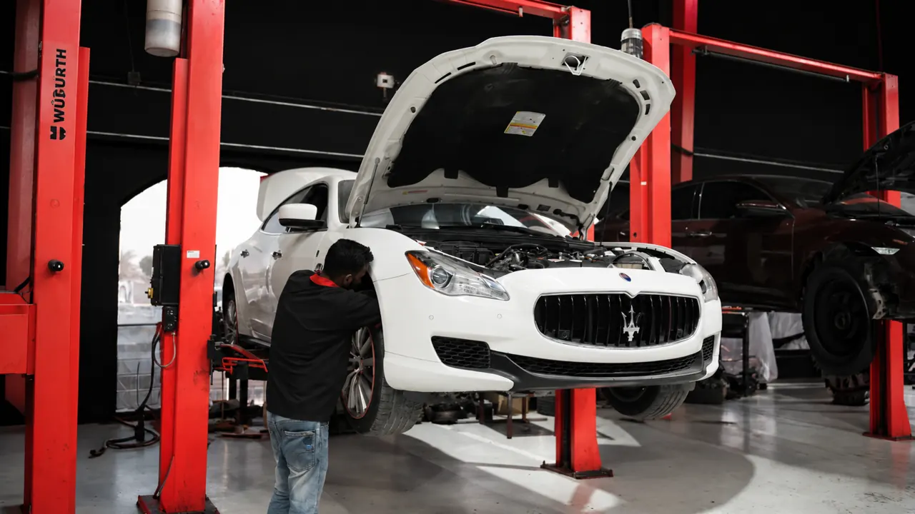 A technician working on a Maserati Quattroporte in the bay at Al Zaabi Autocare, Mussafah