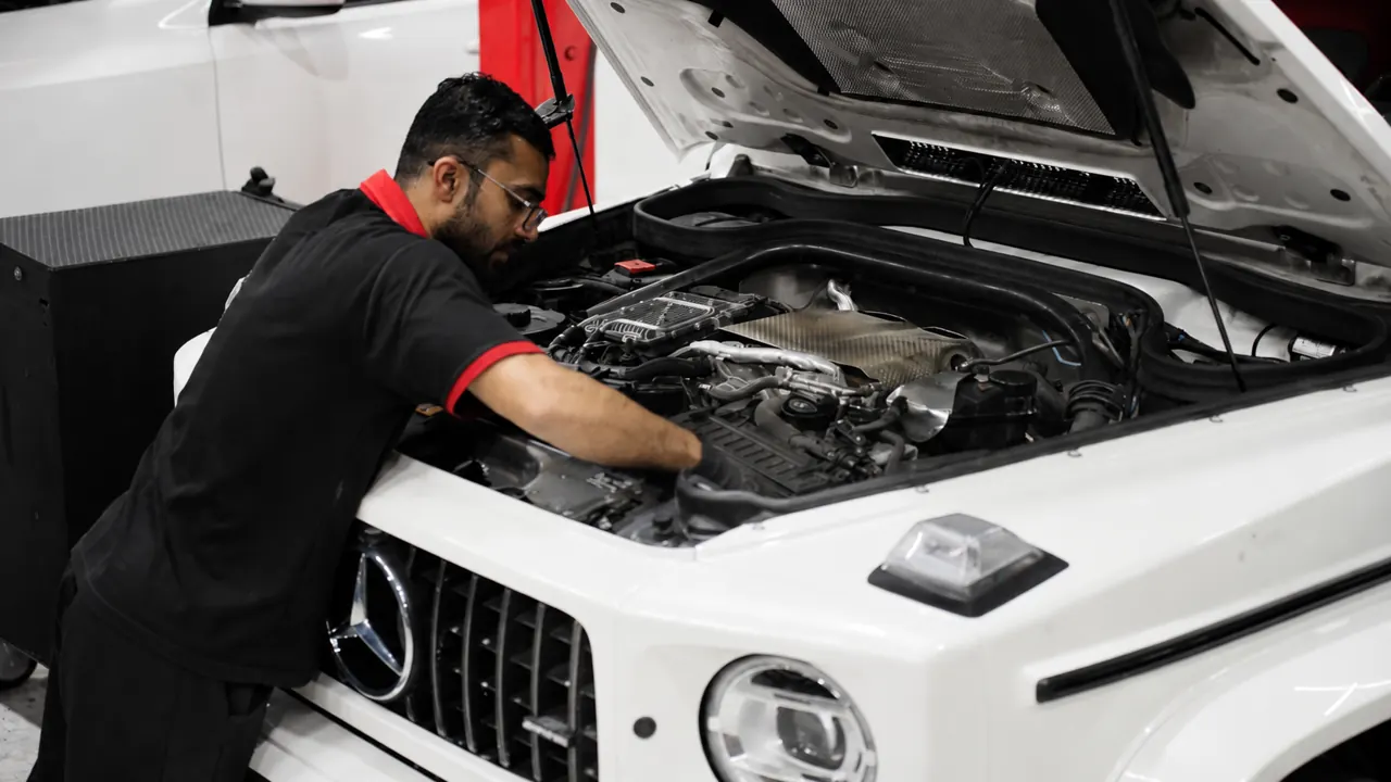 A technician working in the engine bay of a Mercedes G-Class in the bay at Al Zaabi Autocare, Mussafah