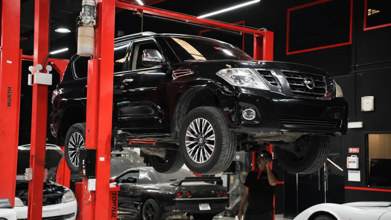 A Nissan Patrol raised on a lift in the bay at Al Zaabi Autocare, Mussafah