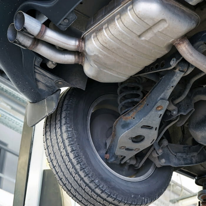A mechanic inspecting a car's exhaust system.